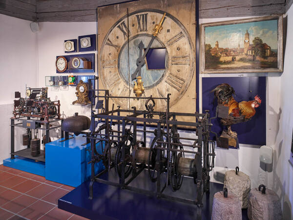 Blick in einen Ausstellungsraum mit Kirchturmuhr